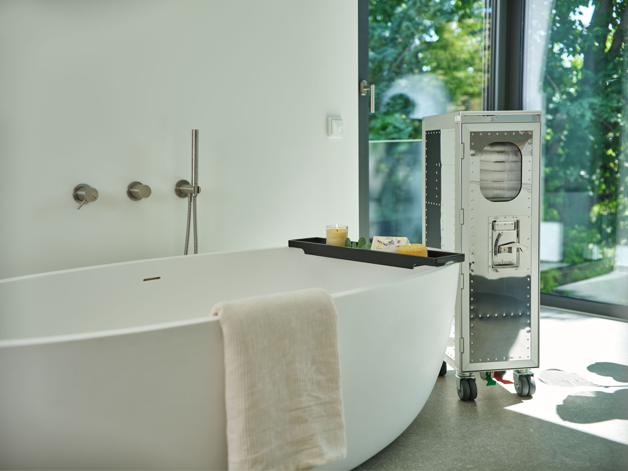 Rivet Rocker Flugzeugtrolley mit Fenster Bordbar im Badezimmer neben einer Badewanne.