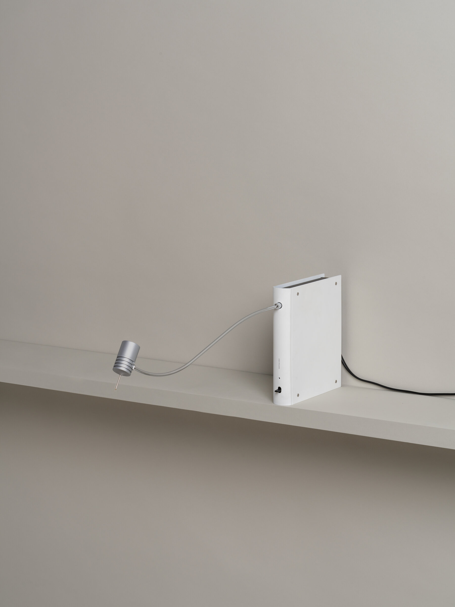 Bib Luz Tischleuchte von Santa & Cole in Off White auf einem Regal.