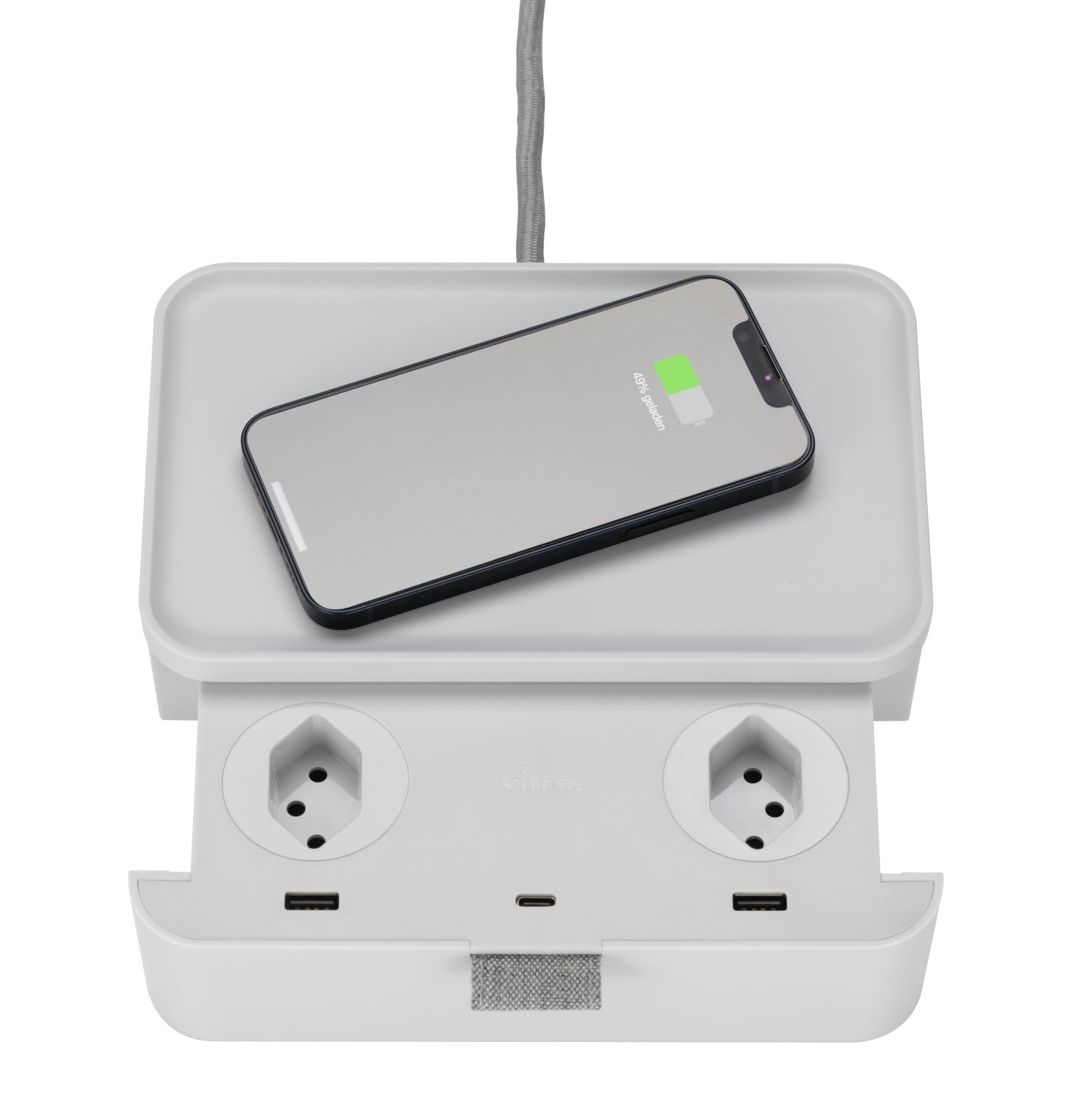 Weißer Vitra Ampi Wireless Charger mit Mehrfachsteckdose und aufladendem Smartphone auf der Ladefläche.