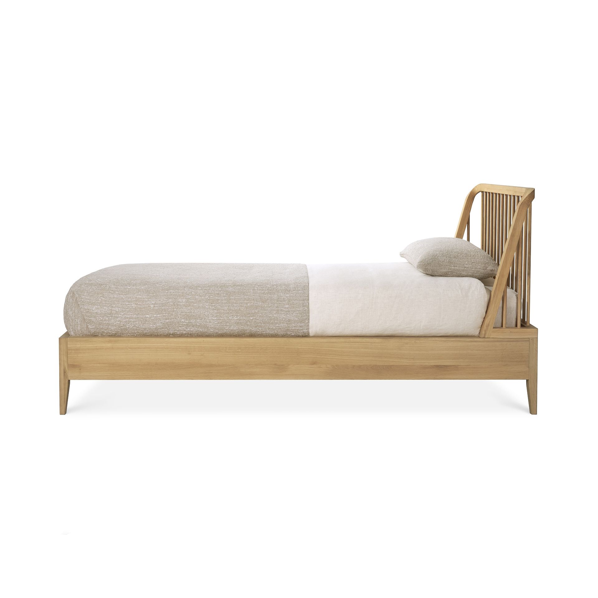 Ethnicraft Spindle Bett Einzelbett aus hellem Holz mit Lattenrost und Kissen.