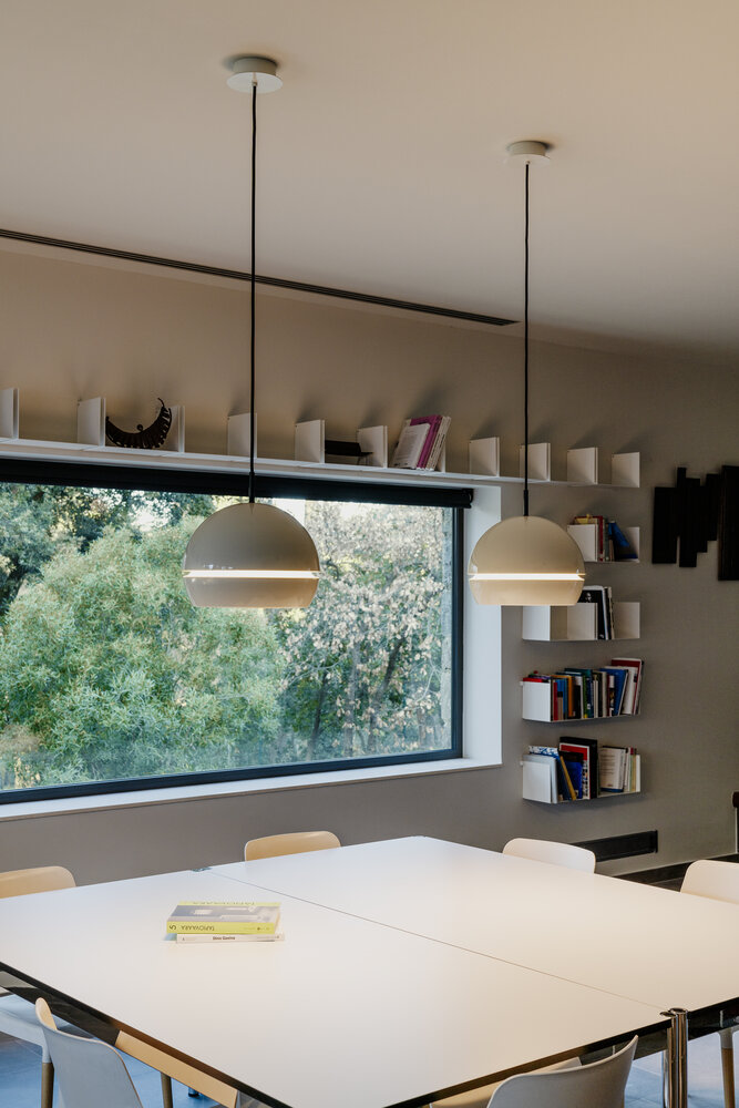 Zwei Fontana Pendelleuchten von Santa & Cole über einem weißen Tisch in einem hellen Raum.