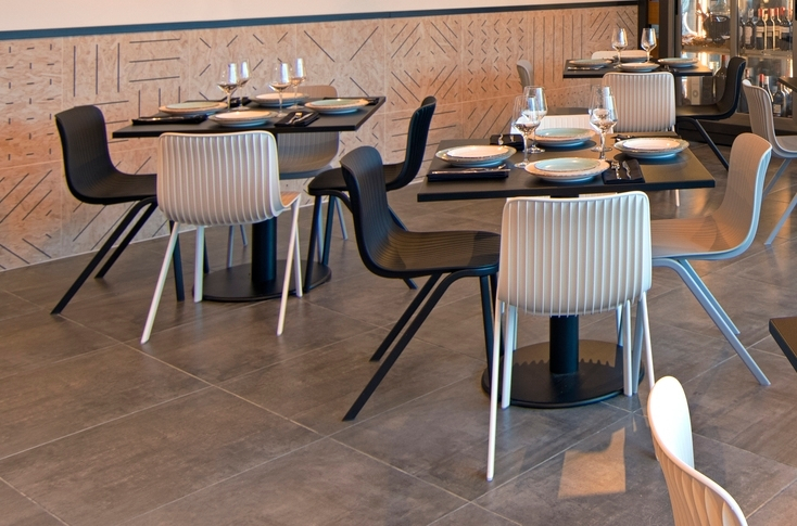 Weißer Dragonfly Stuhl von Segis mit Metallbeinen an gedecktem Tisch im Restaurant.