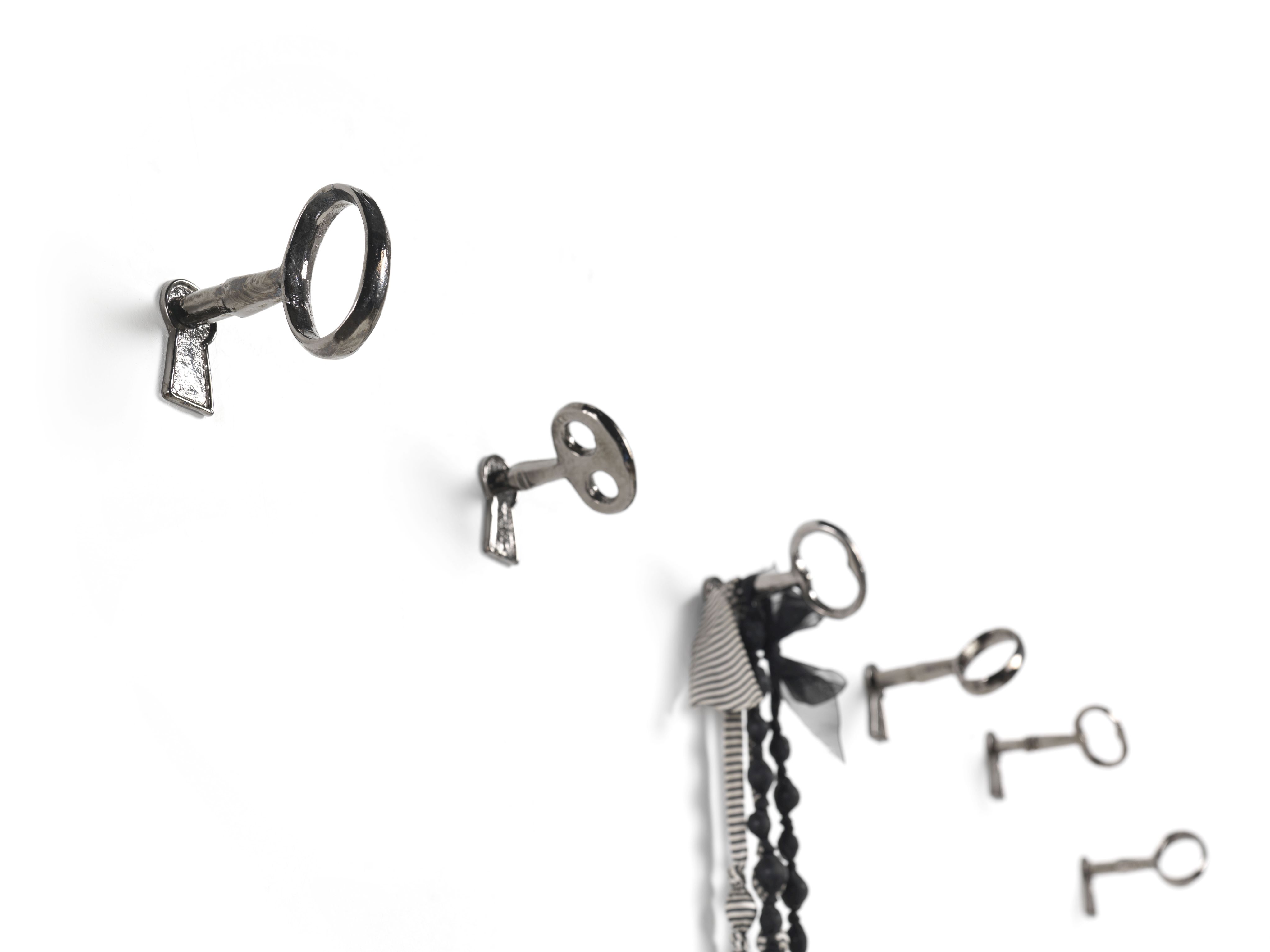 Memorie Wandhaken von Mogg: Vier silberne Schlüssel als Wandhaken, einer mit Dekoration.