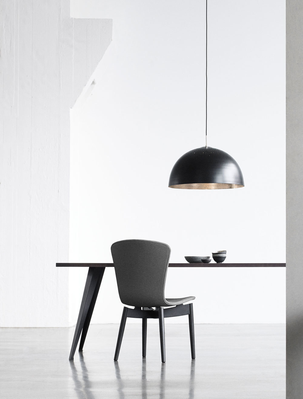 Schwarze Shade Pendelleuchte von Mater über Esstisch mit Stuhl, moderne Innenraumbeleuchtung.