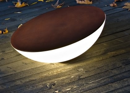 SOLAR Bodenleuchte von Foscarini, moderne Außenleuchte in braun und weiß auf Holzterrasse.