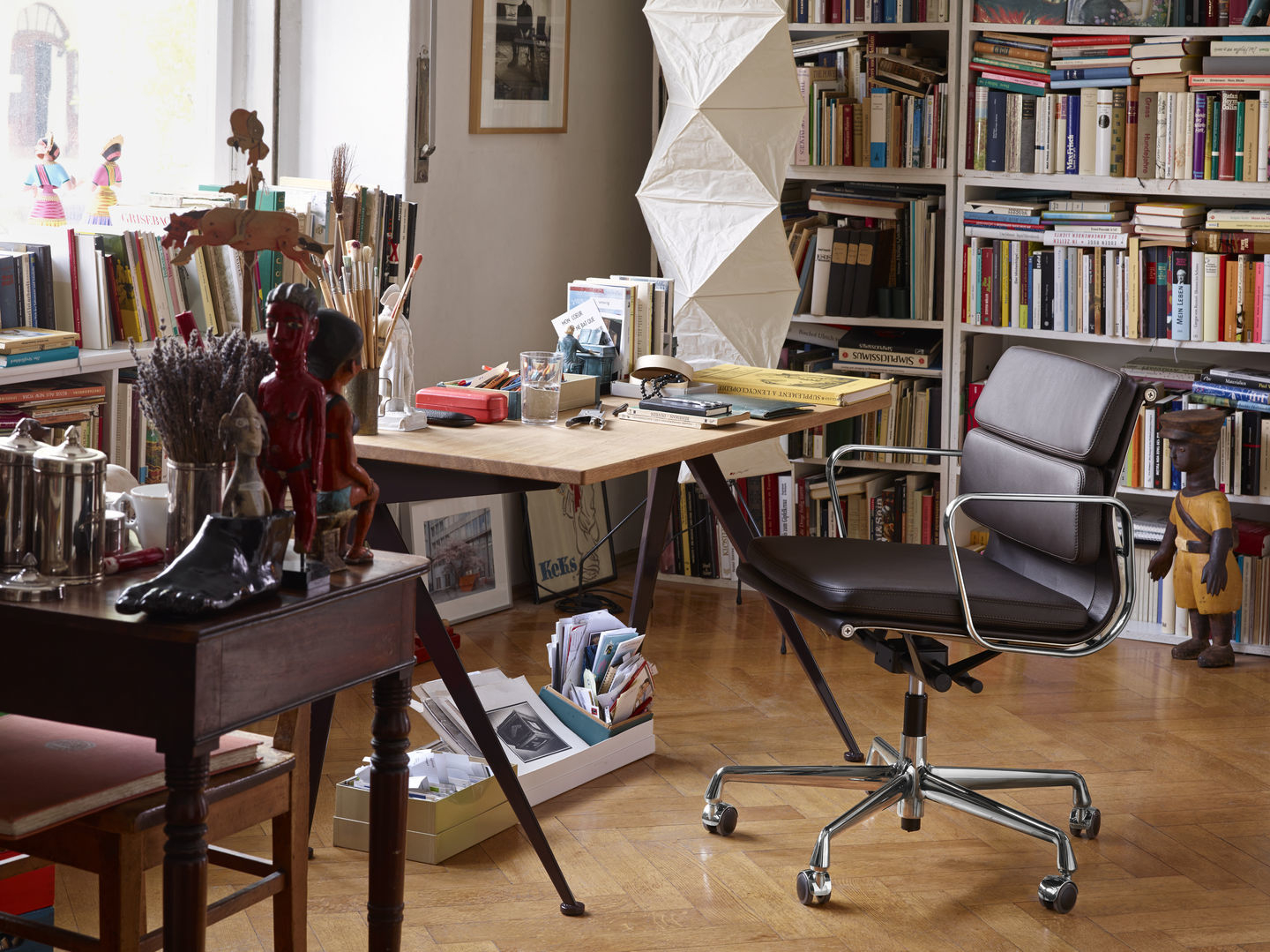 Brauner Soft Pad Chair EA217 von Vitra im Arbeitszimmer mit Schreibtisch und Bücherregal.