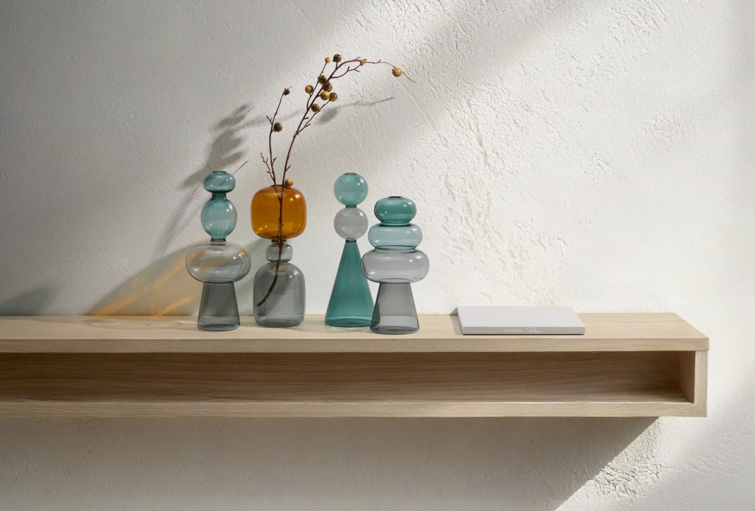 Curiosa Vase von Philippi: Mehrfarbige Glasvasen im Sanduhr-Design auf einem Holzregal. Dekorative Wohnaccessoires.