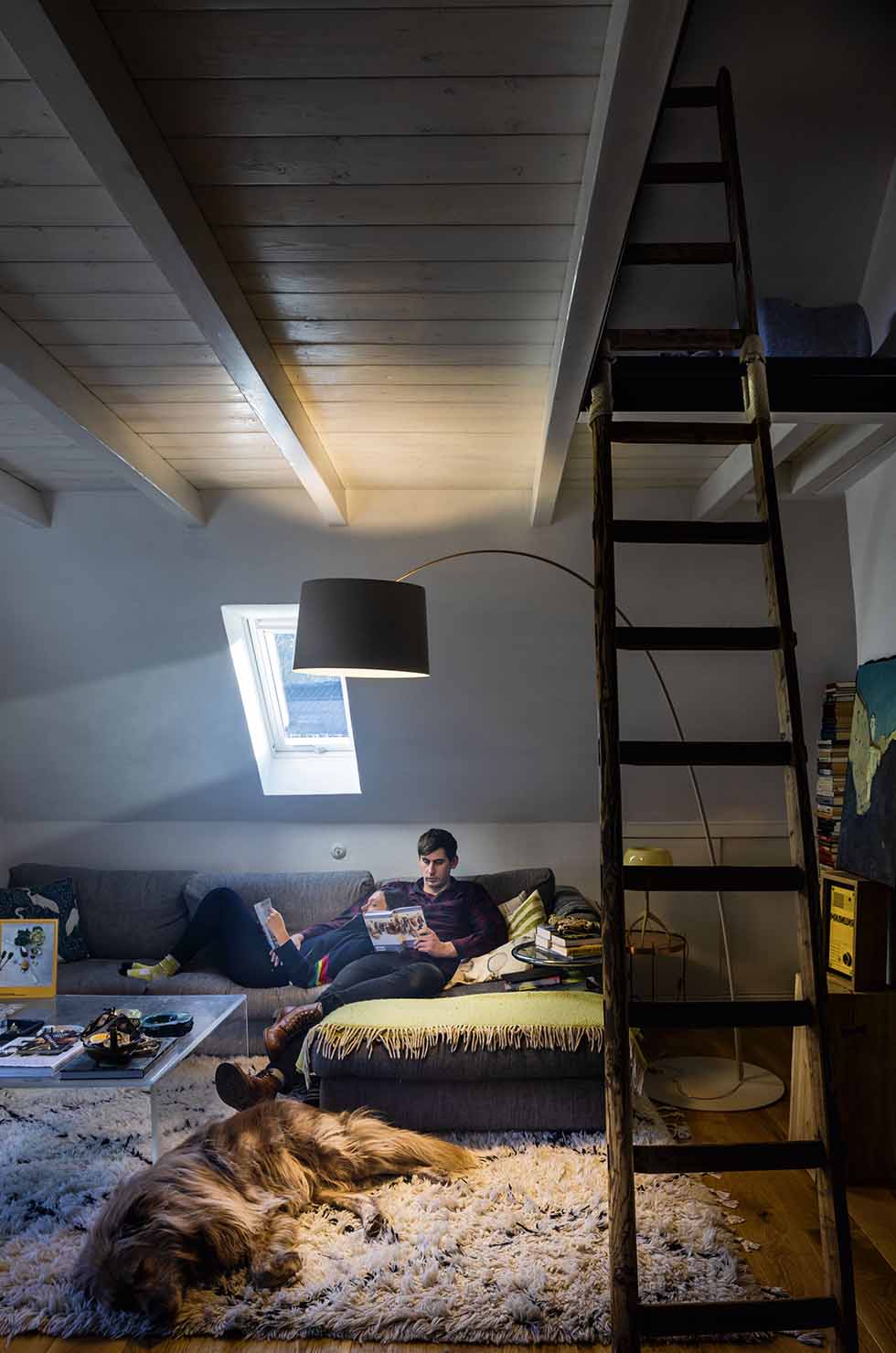 Wohnzimmer mit Twiggy LED Stehleuchte von Foscarini in Schwarz, die eine gemütliche Leseecke beleuchtet.