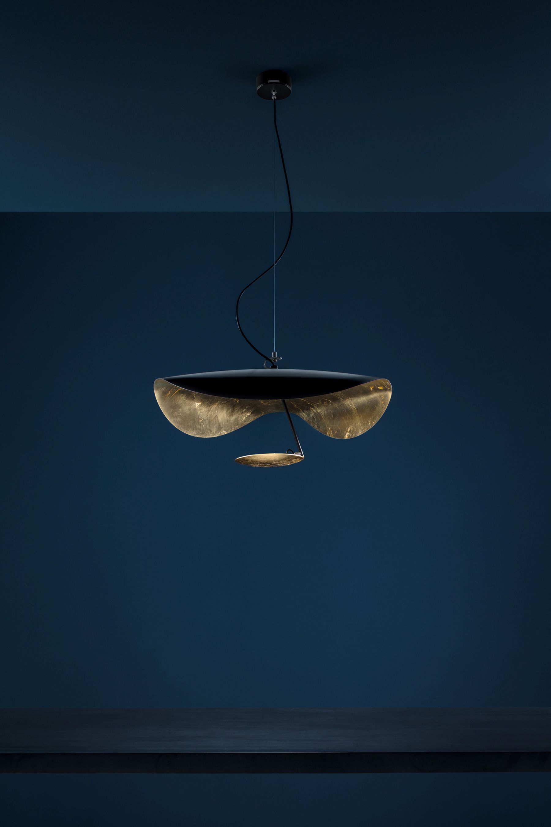 Lederam Pendelleuchte von Catellani & Smith: Moderne Hängelampe mit goldenen Reflektoren und warmem Licht.