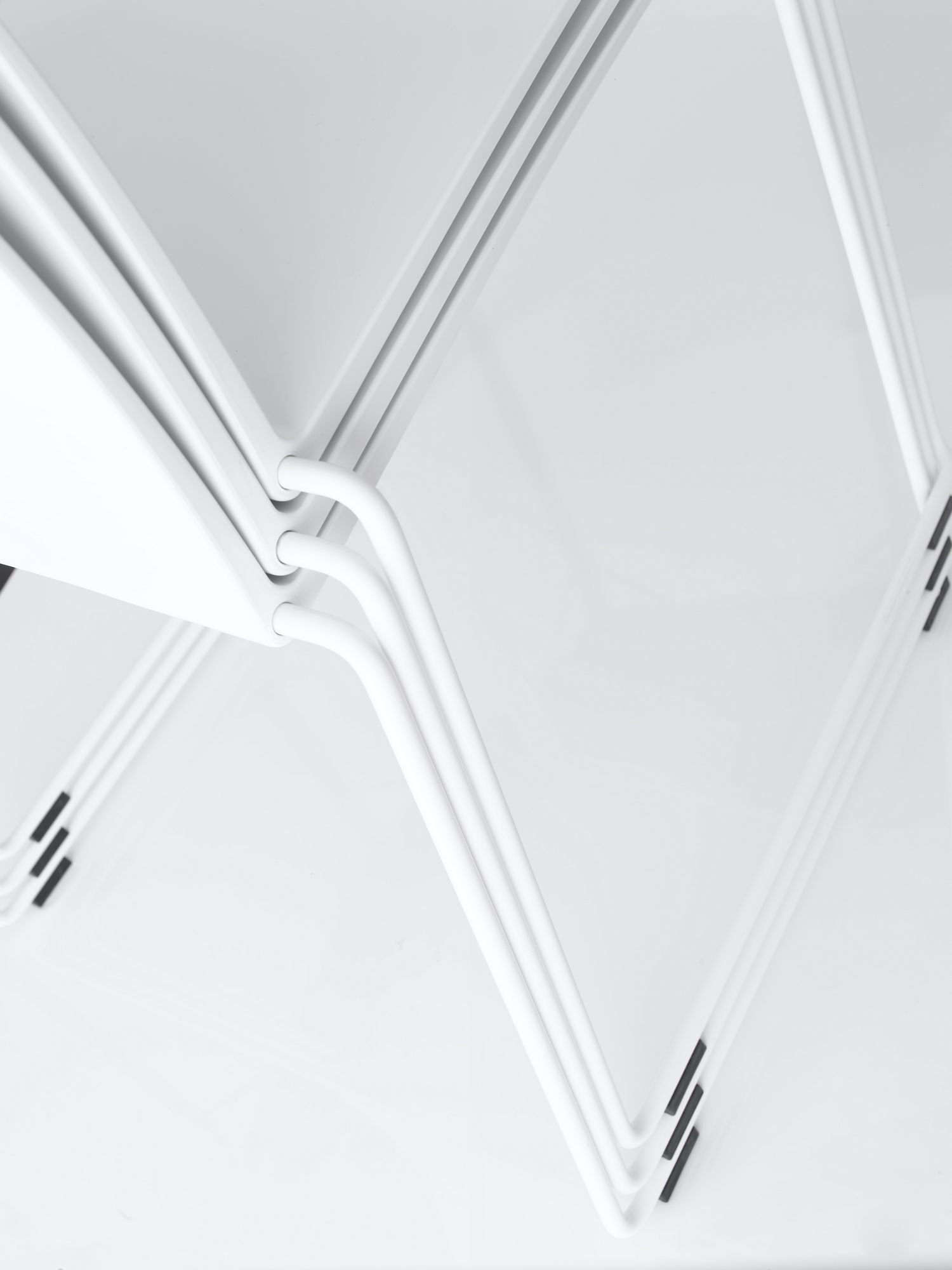Detailaufnahme von gestapelten, weißen M1 Stühlen von MDF Italia. Minimalistisches Design.