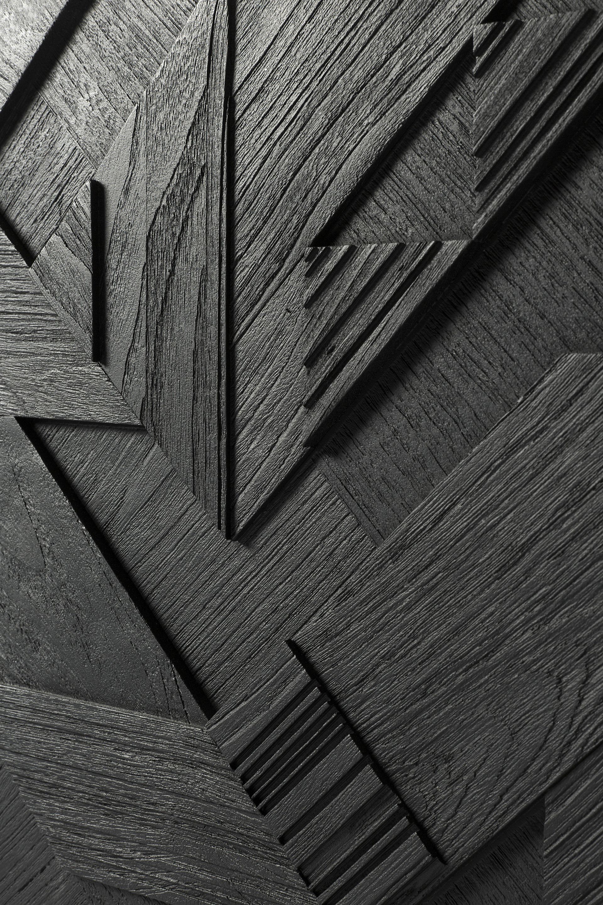 Detailaufnahme der schwarzen Graphic Teak Anrichte von Ethnicraft mit geometrischem Muster und Holzmaserung.