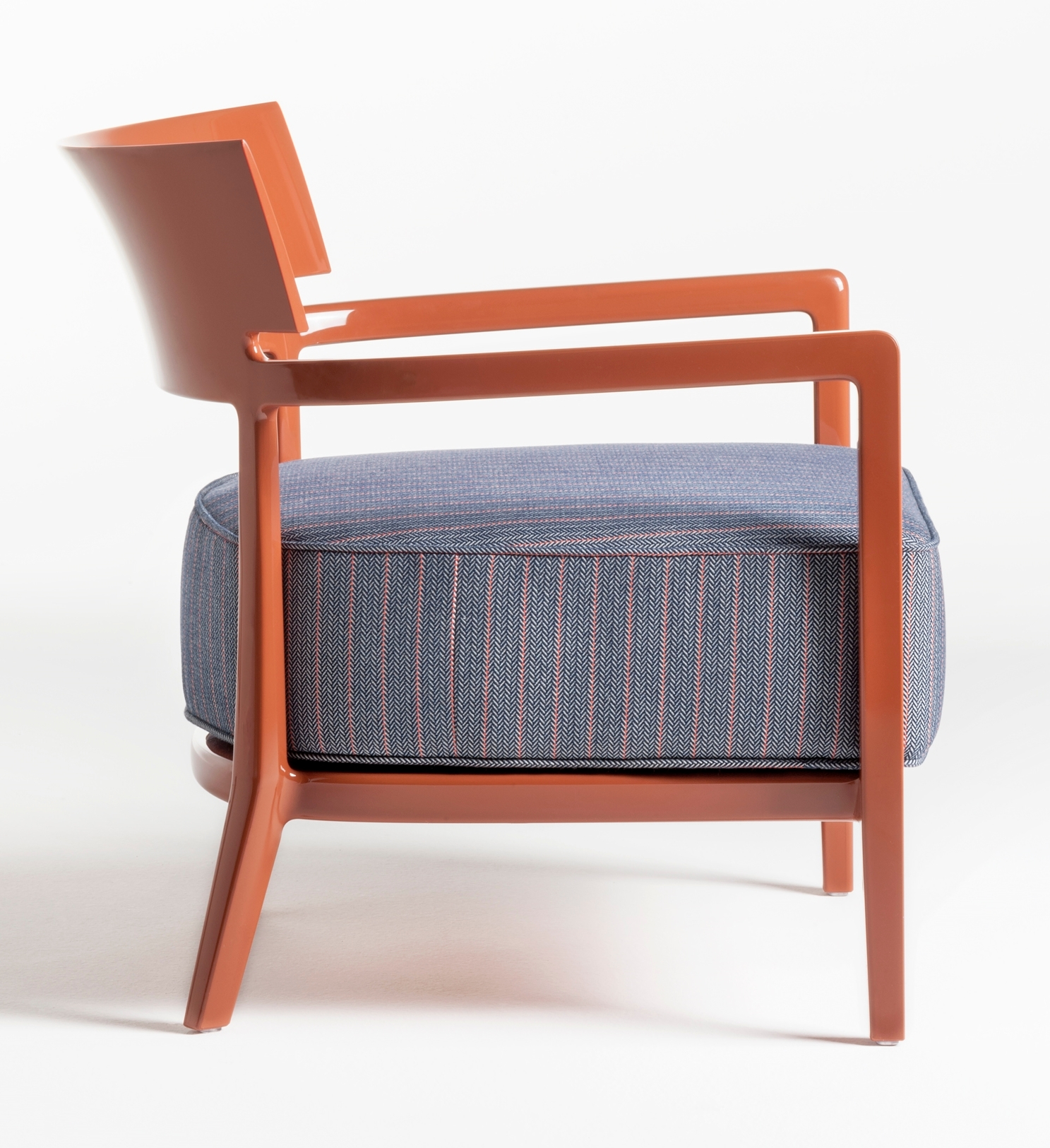 Cara Outdoor Sessel von Kartell, Seitenansicht: Moderner Gartensessel in Terrakotta mit blau gestreiftem Sitzkissen.