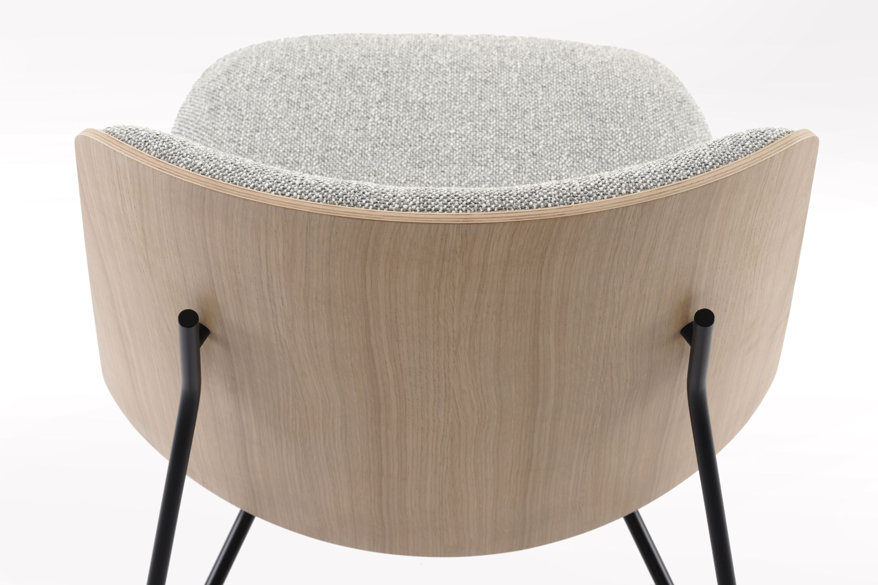 Rückansicht des Prostoria Tinker Sessels mit hellgrauem Stoffbezug und hellem Holzfurnier auf schwarzem Metallgestell.