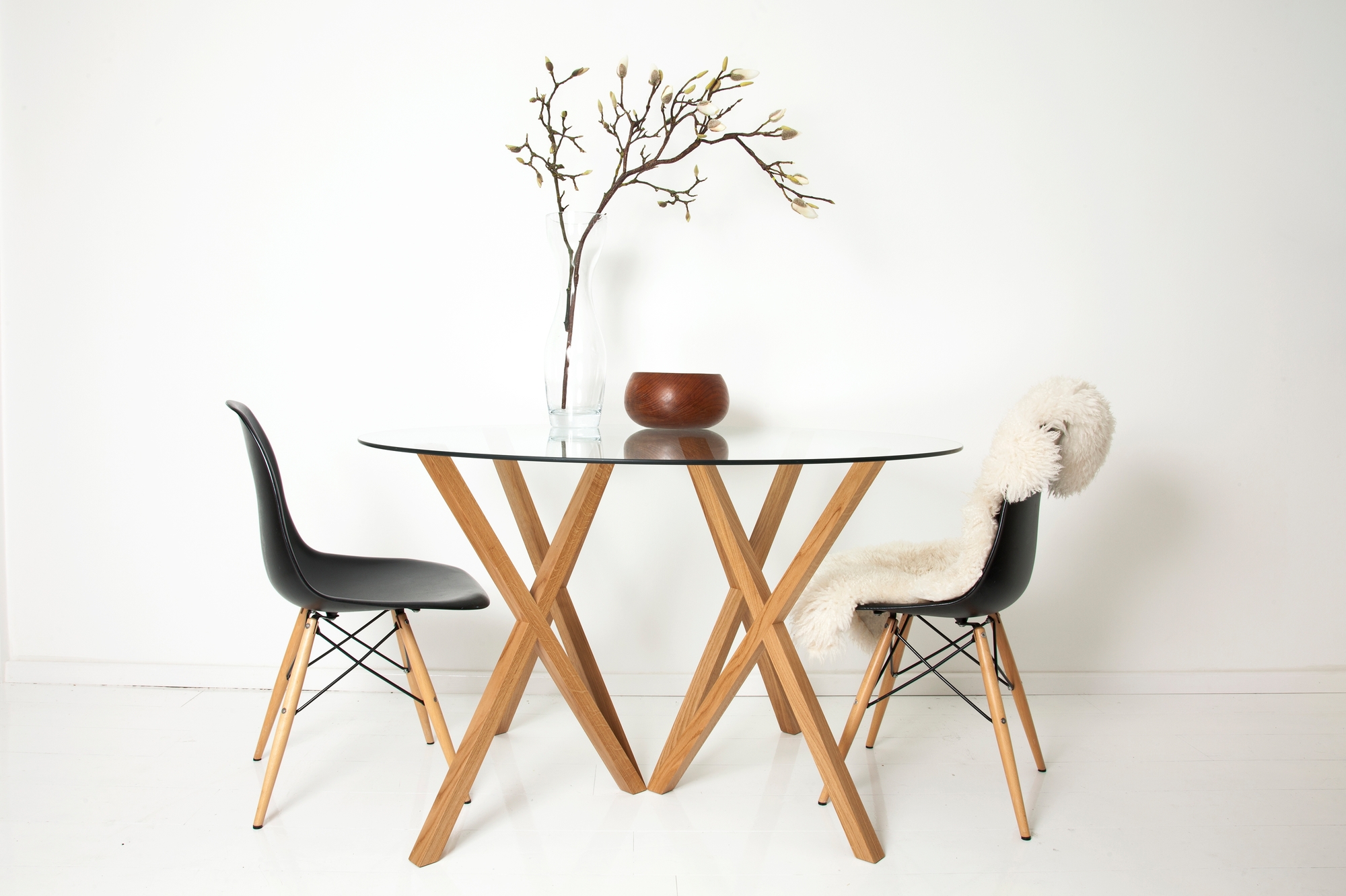 Runder Glastisch mit Mika Tischbeinen von Hans Hansen und zwei Stühlen im minimalistischen Design.