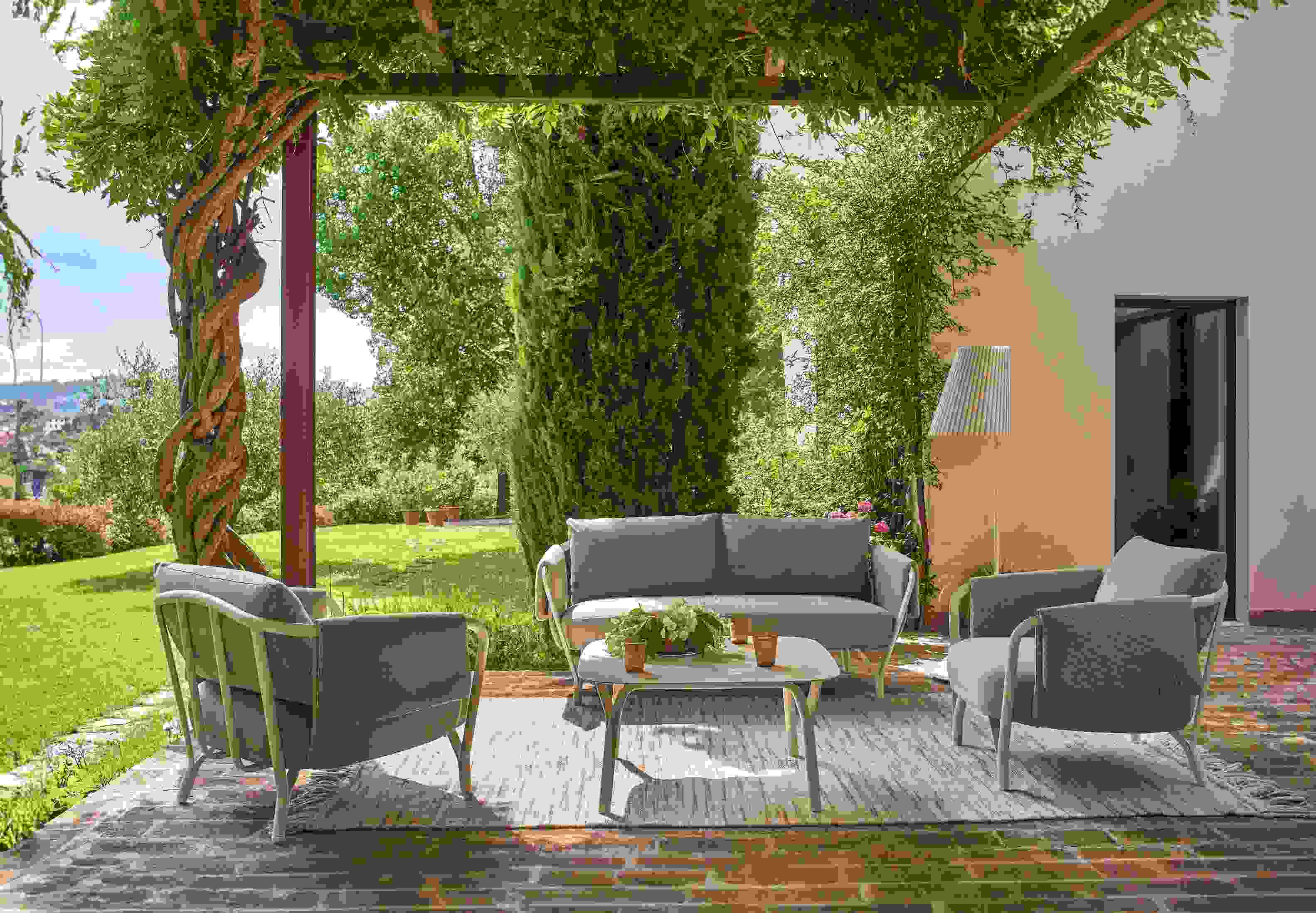 Angel niedriger Tisch von Emu, Teil einer grauen Outdoor-Lounge-Gruppe auf einer Terrasse.