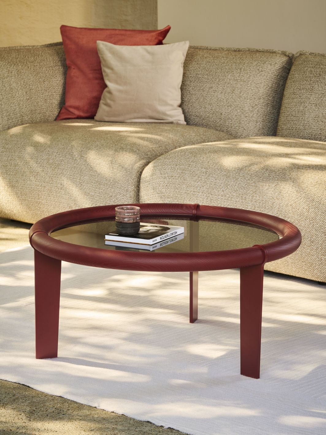 Roter Boia Couchtisch mit Glasplatte vor beigem Sofa. Modernes Wohnzimmer Design.
