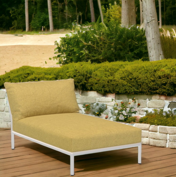 Houe Level 2 Chaiselongue: Outdoor Sessel mit gelbem Bezug und weißem Gestell im Garten.