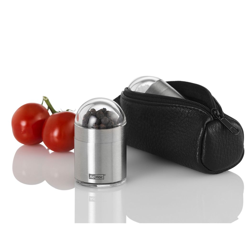 AdHoc PEKNICK ToGo Set: Edelstahl Pfeffermühle mit schwarzer Ledertasche und zwei Tomaten.