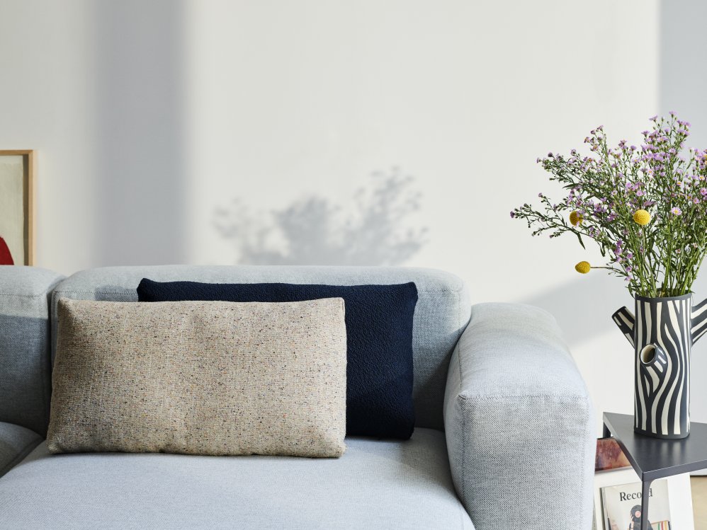 Nahaufnahme: Mags Soft Sofa mit beigen Kissen und Armlehne. Gemütliches Wohnzimmer-Ambiente.