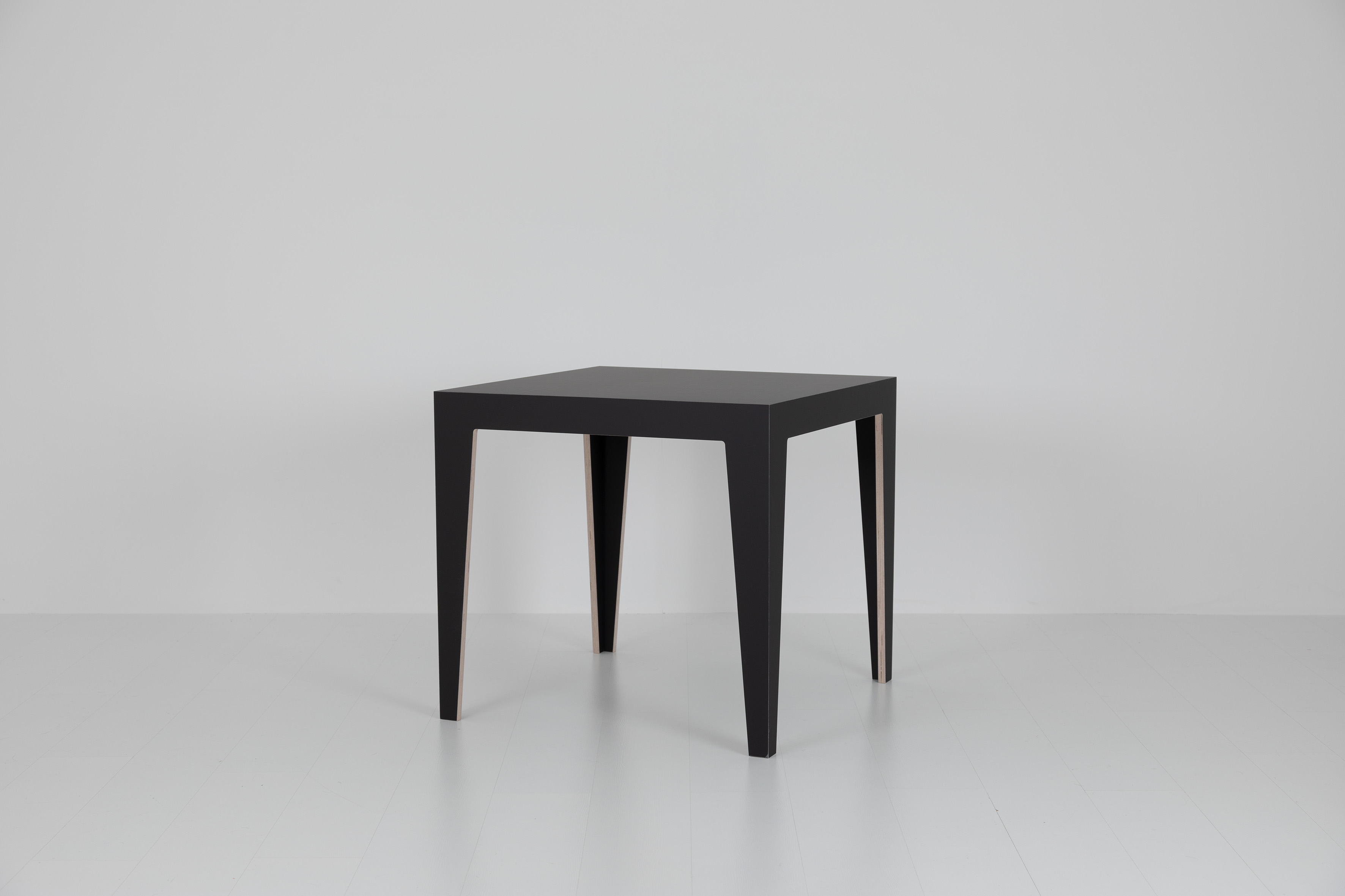 Schwarzer MARTA Holztisch mit minimalistischem Design und vier Beinen auf weißem Hintergrund.