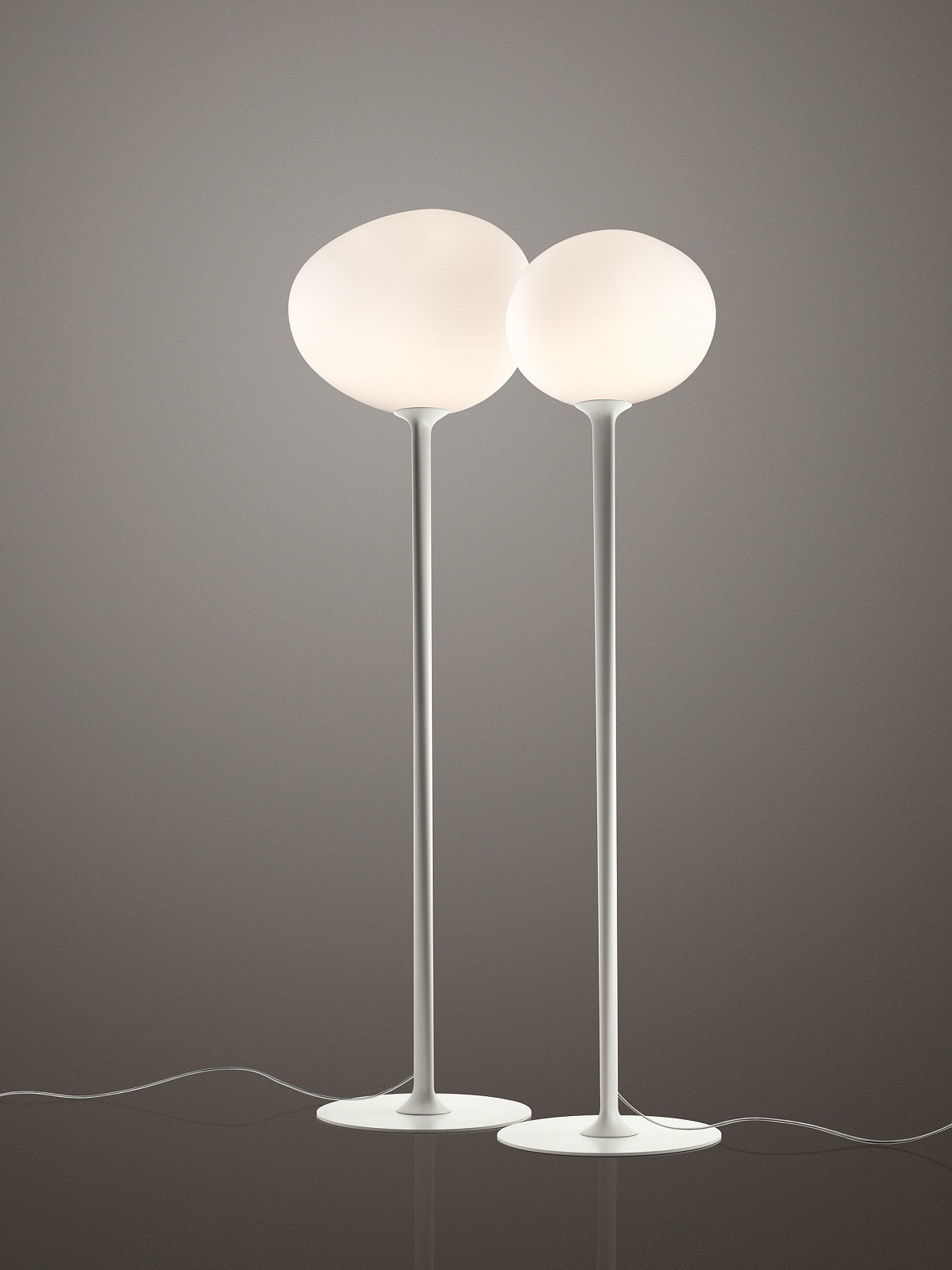 Zwei moderne Gregg Stehleuchten von Foscarini mit runden, diffusen Lampenschirmen.