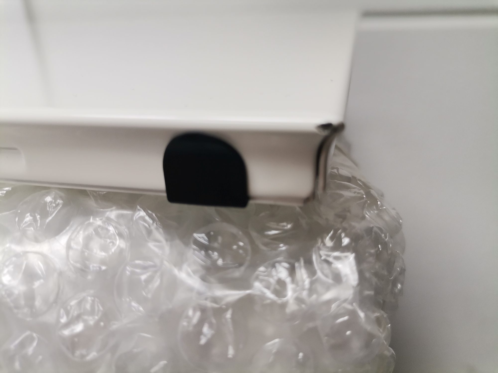 Detailaufnahme von verpackten USM Haller Ersatzteilen, Mängelexemplar mit Luftpolsterfolie und weißem Karton.