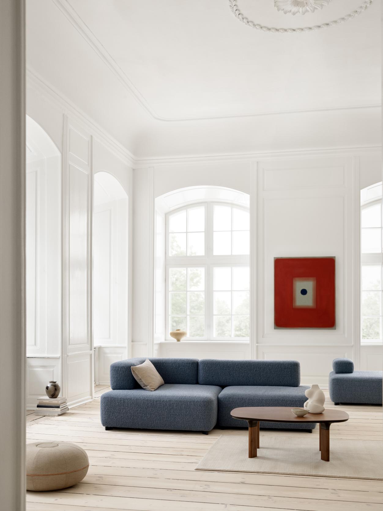 Wohnzimmer mit Fritz Hansen Pouf Hocker in warmem Sand, bequemer Sitzgelegenheit und stilvollem Design.