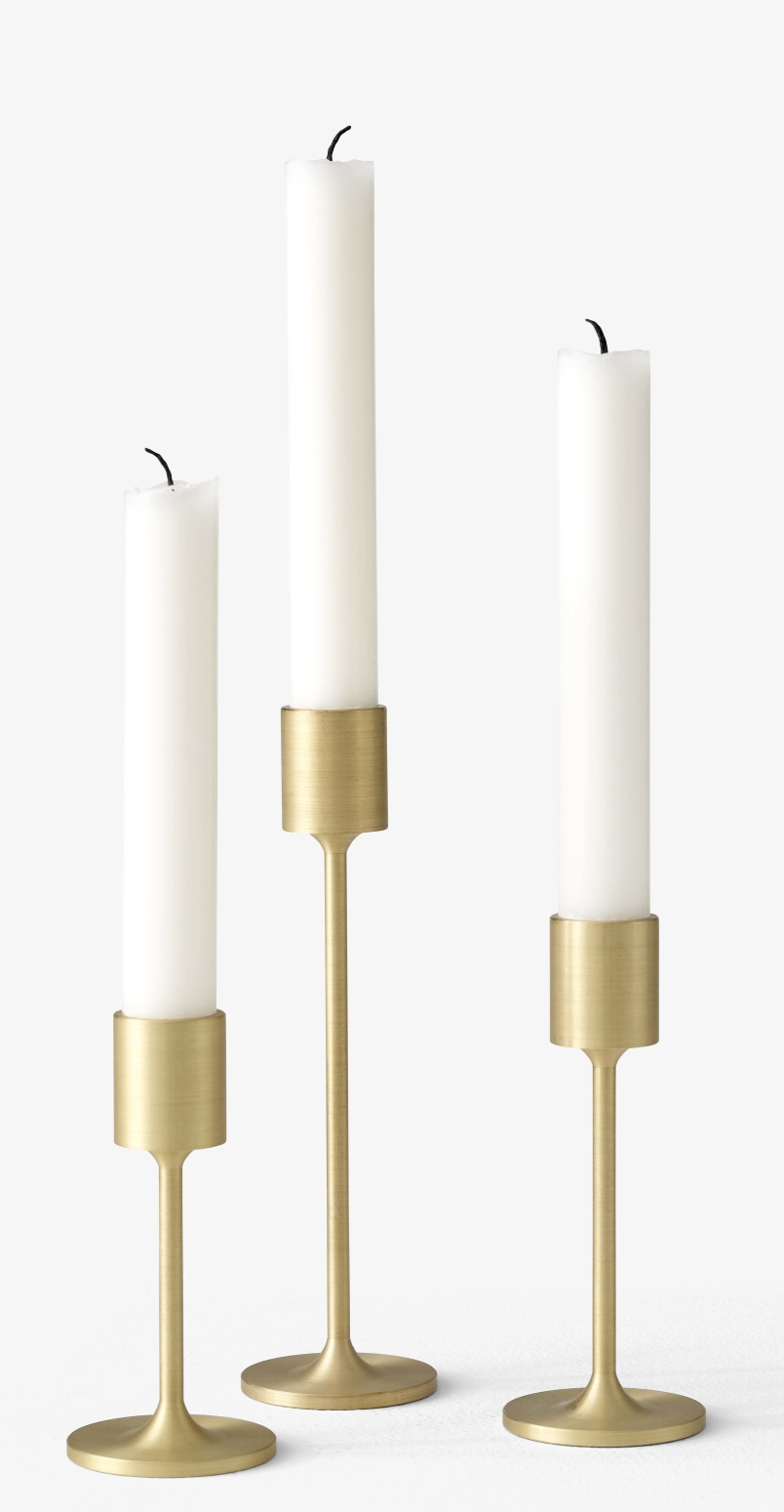 Drei goldene Kerzenhalter mit weißen Stabkerzen. AndTradition Kerzenhalter für stilvolle Dekoration.