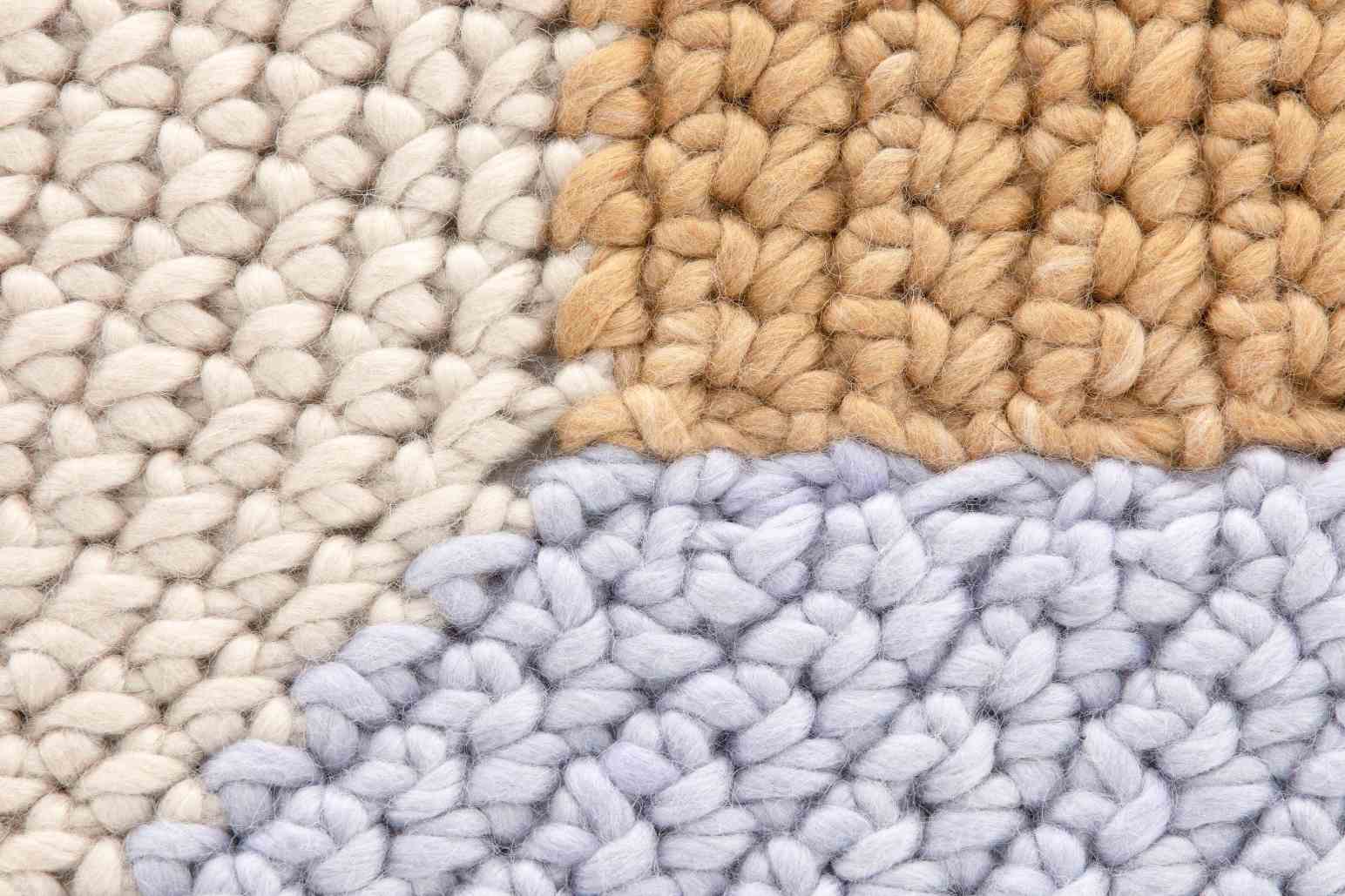 Detailaufnahme des The Crochet Collection Teppichs in Beige, handgefertigt mit aufwendiger Stickerei und Textur.