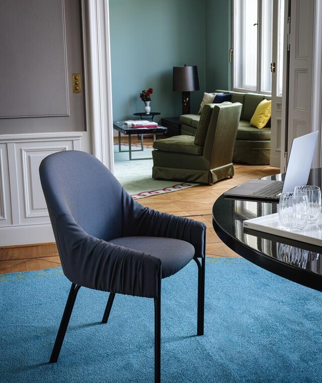Blauer Celine Armchair Low Sessel von Freifrau Manufaktur mit gerafften Armlehnen und schwarzen Beinen.