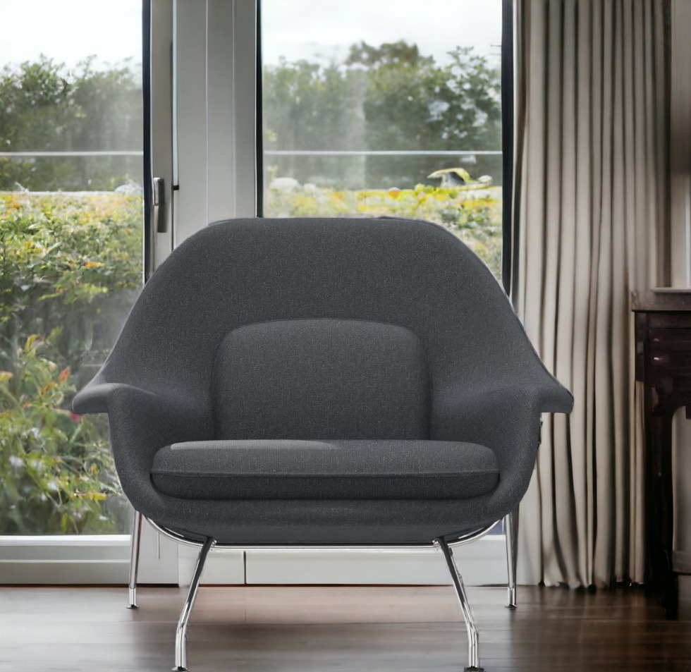 Grauer Womb Chair Sessel von Knoll International mit verchromten Beinen vor Fenster und Vorhang.