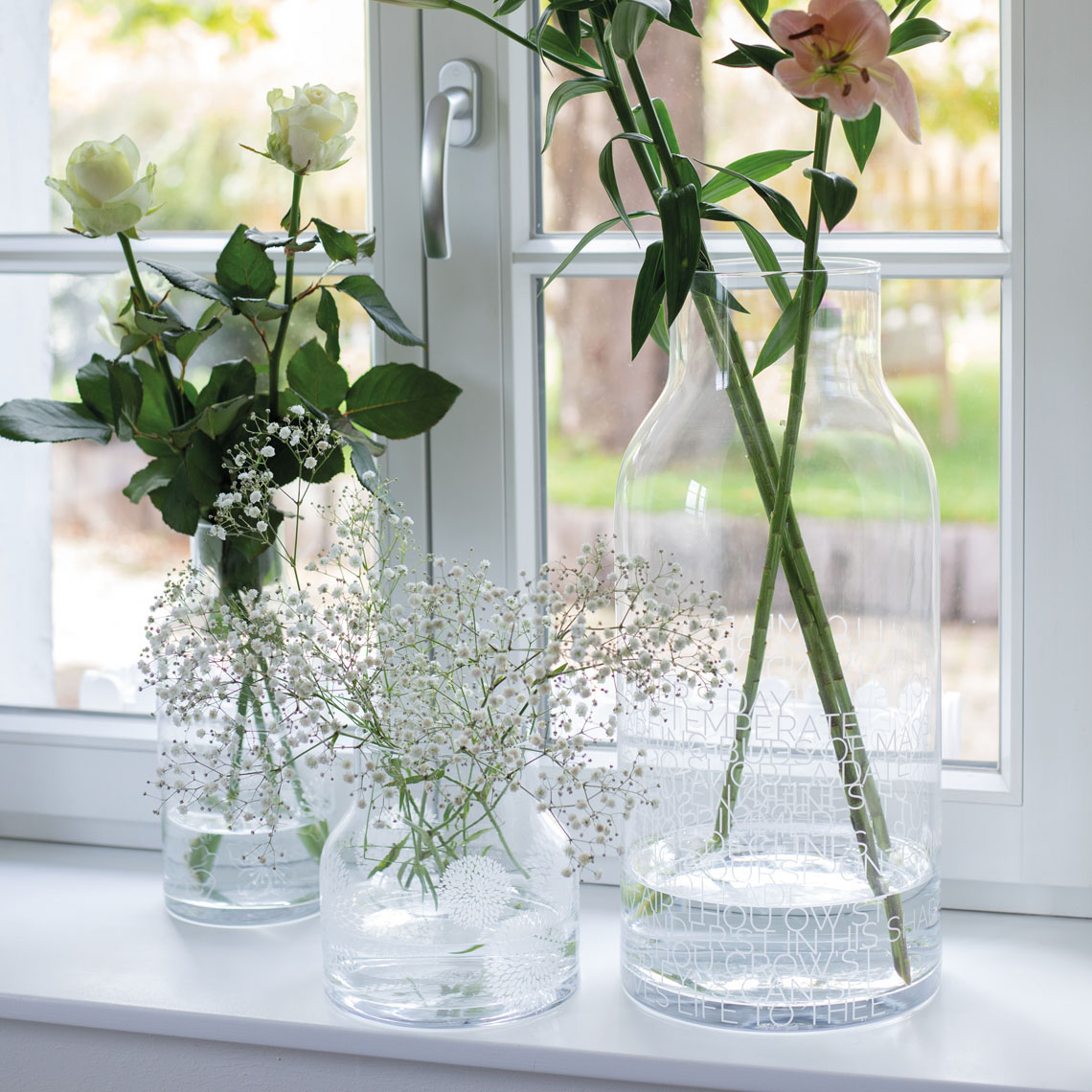 Drei Living Glasvasen mit Blumen auf einer Fensterbank, dekorative Blumenvase für Zuhause.
