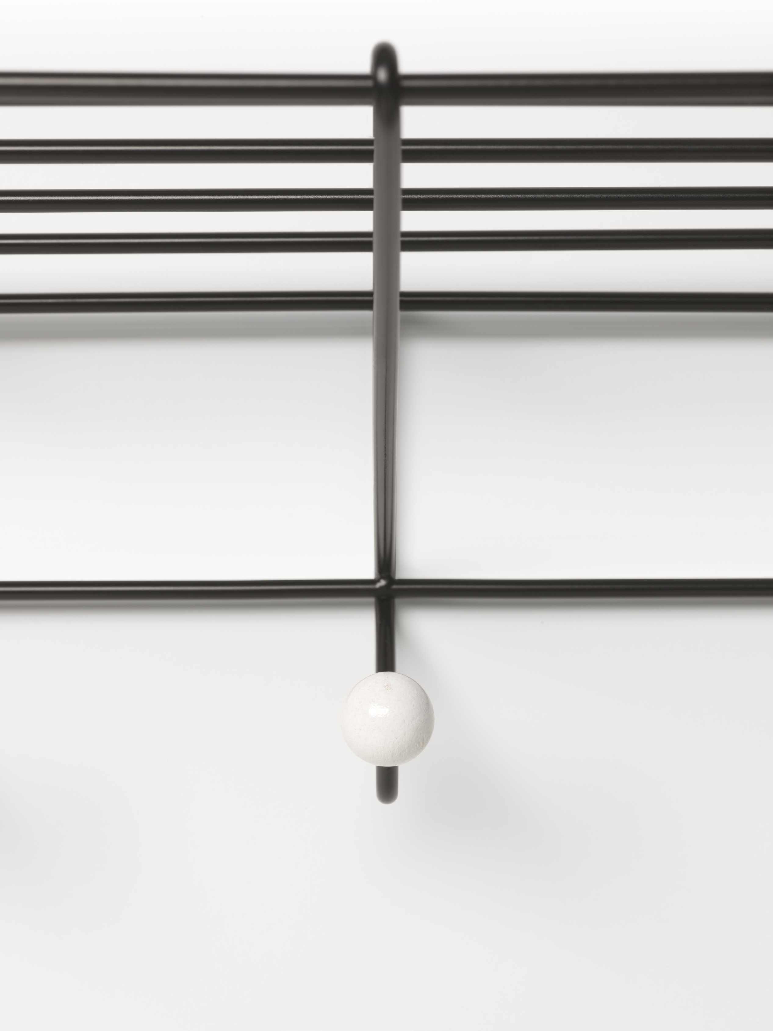 Detailaufnahme der DZ 05 Garderobe Spectrum: Schwarzes Metallgestell mit weißem Knauf. Moderne Wandgarderobe.