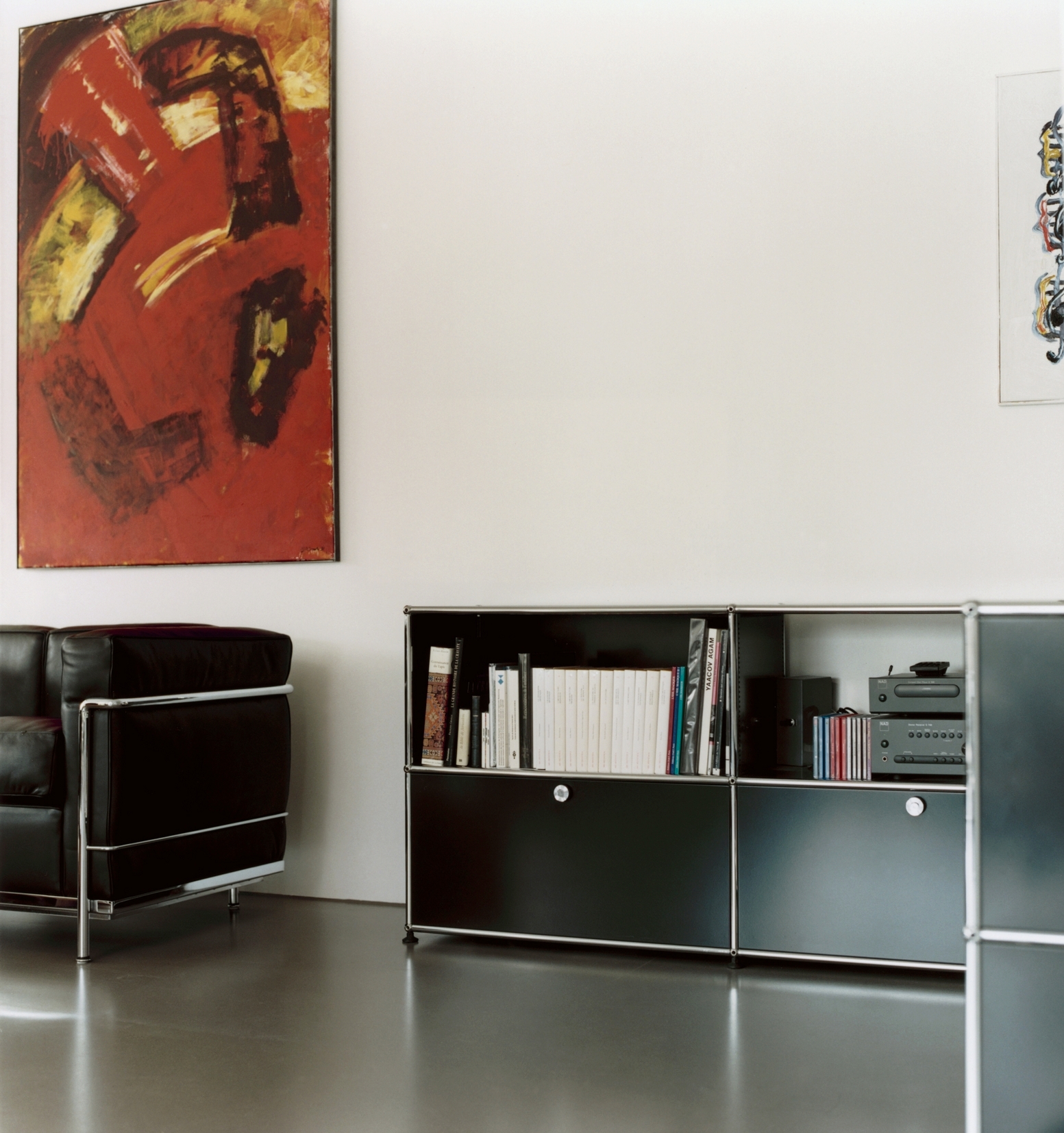 Nahaufnahme eines schwarzen USM Haller Sideboards mit Schubladen und Büchern im Wohnzimmer.