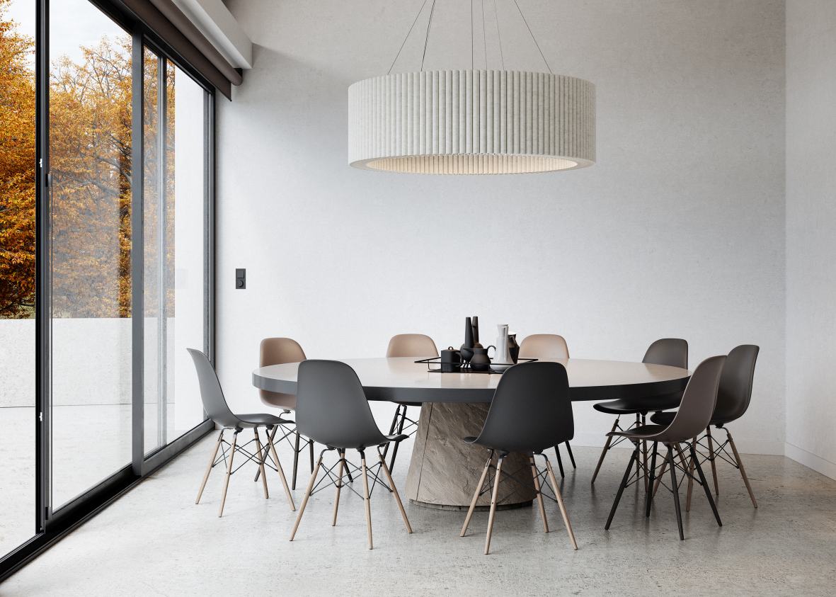 Helles Esszimmer mit rundem Tisch, Stühlen und Hey Sign Welle Deckenobjekt als Pendelleuchte.