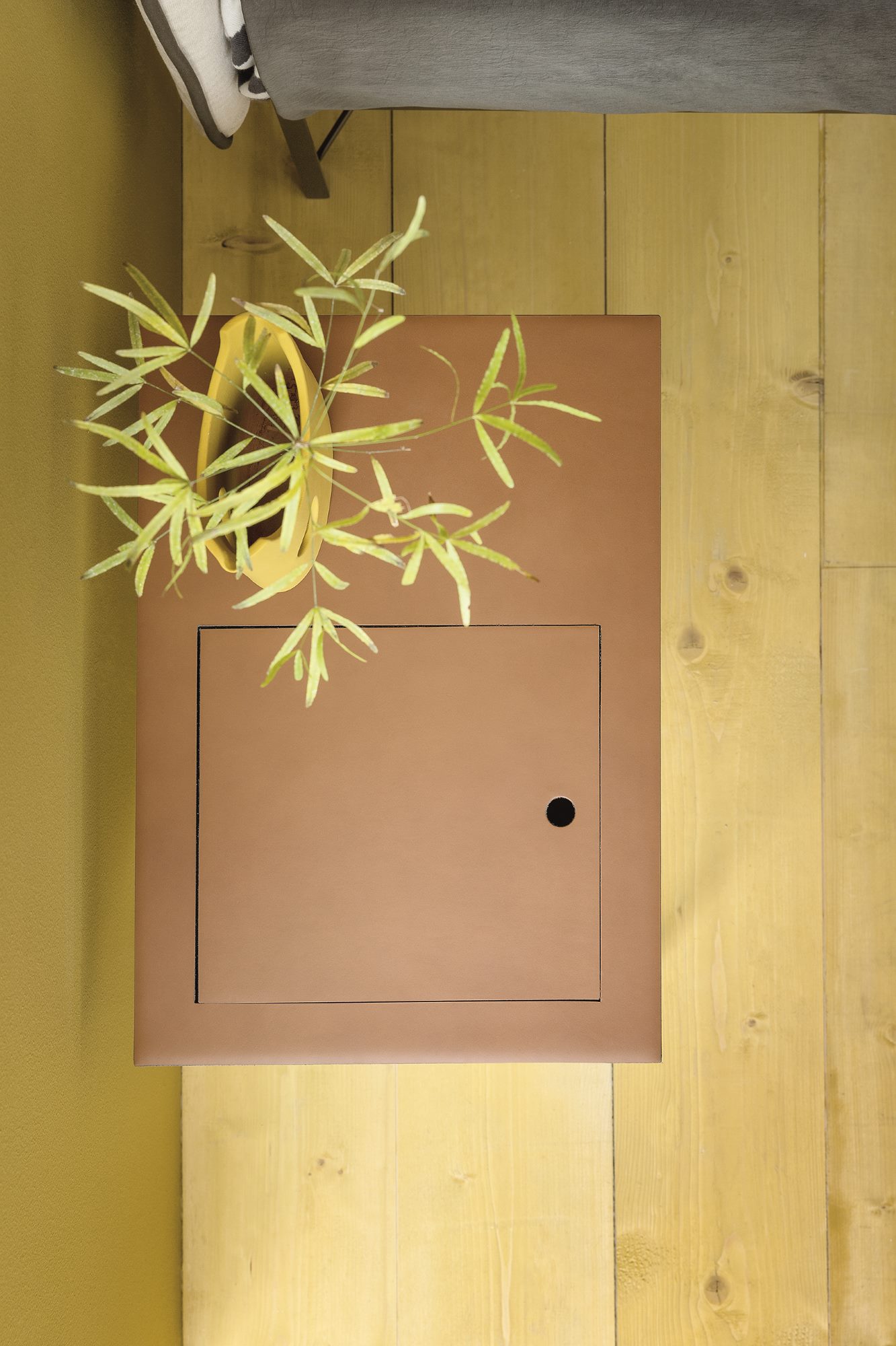 Draufsicht: Brauner Taschino Nachttisch von Zanotta mit Fach und Pflanze auf hellem Holzboden.