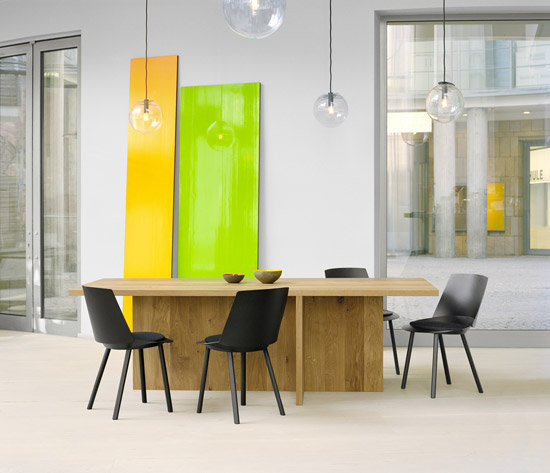 TA18 Zehn Esstisch von e15: Massiver Eichentisch mit schwarzen Stühlen in modernem Interieur.