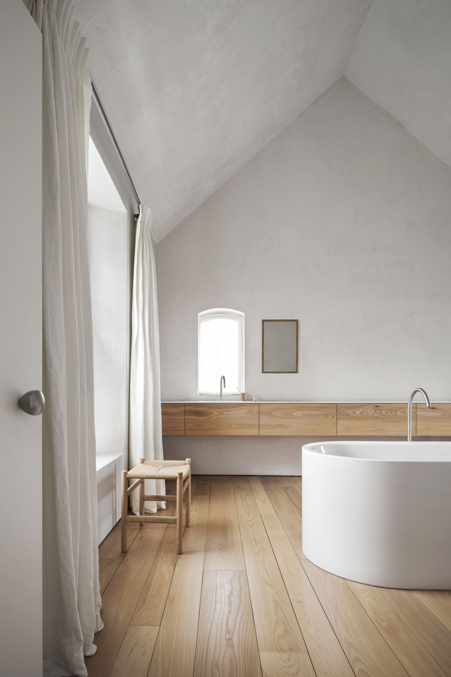 CH53 Hocker von Carl Hansen & Søn im Badezimmer mit Badewanne und Holzfußboden.