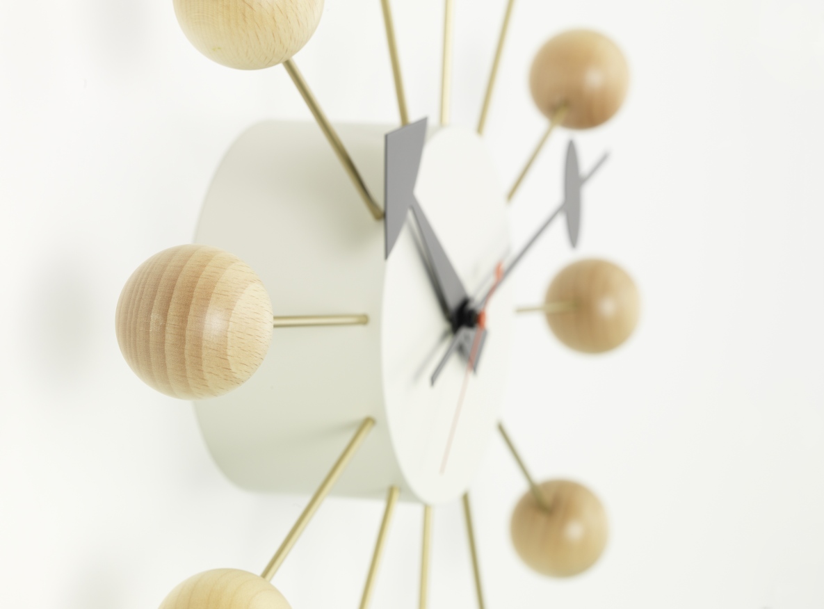 Ball Clock Wanduhr: Detailaufnahme der Design-Uhr mit Holzkugeln und goldenen Streben.