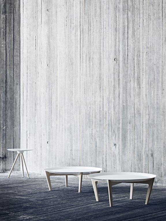 Circo Beistelltische Softline: Drei weiße, runde Tische mit Holzbeinen vor einer Betonwand. Moderner Beistelltisch.
