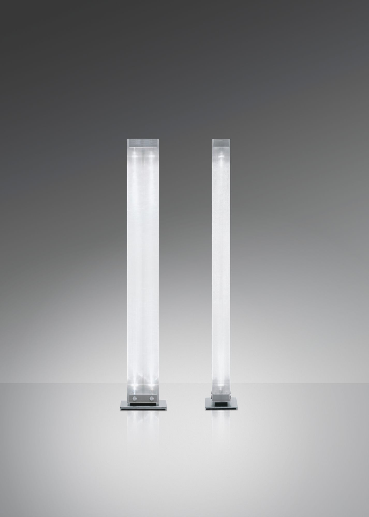 Zwei Twilight LED Stehleuchten von Belux in unterschiedlichen Größen auf grauem Hintergrund.