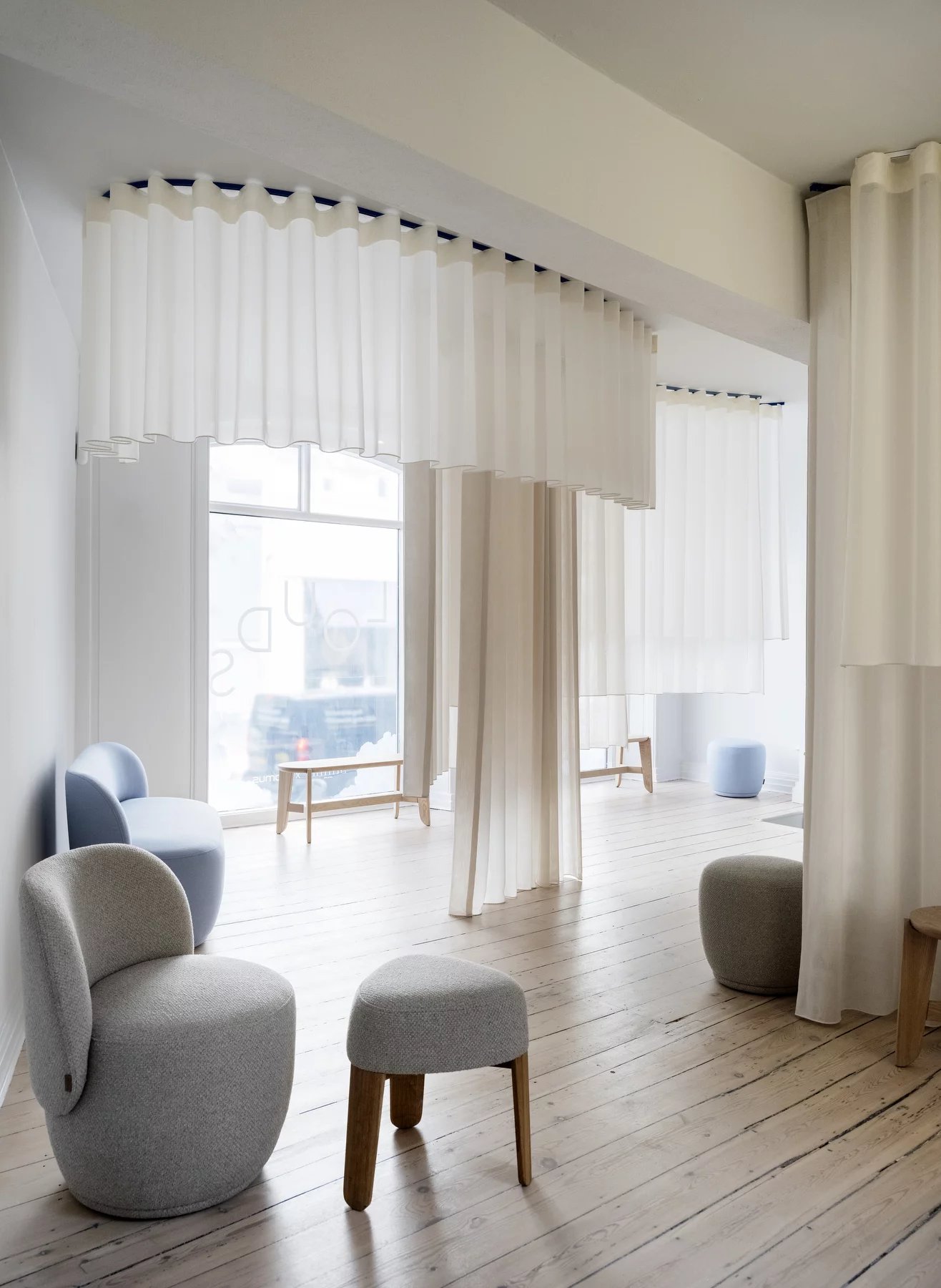 Innenaufnahme mit Blomus Kuon Sessel und Hocker in Shitake-Farbe, moderne Wohnzimmermöbel.