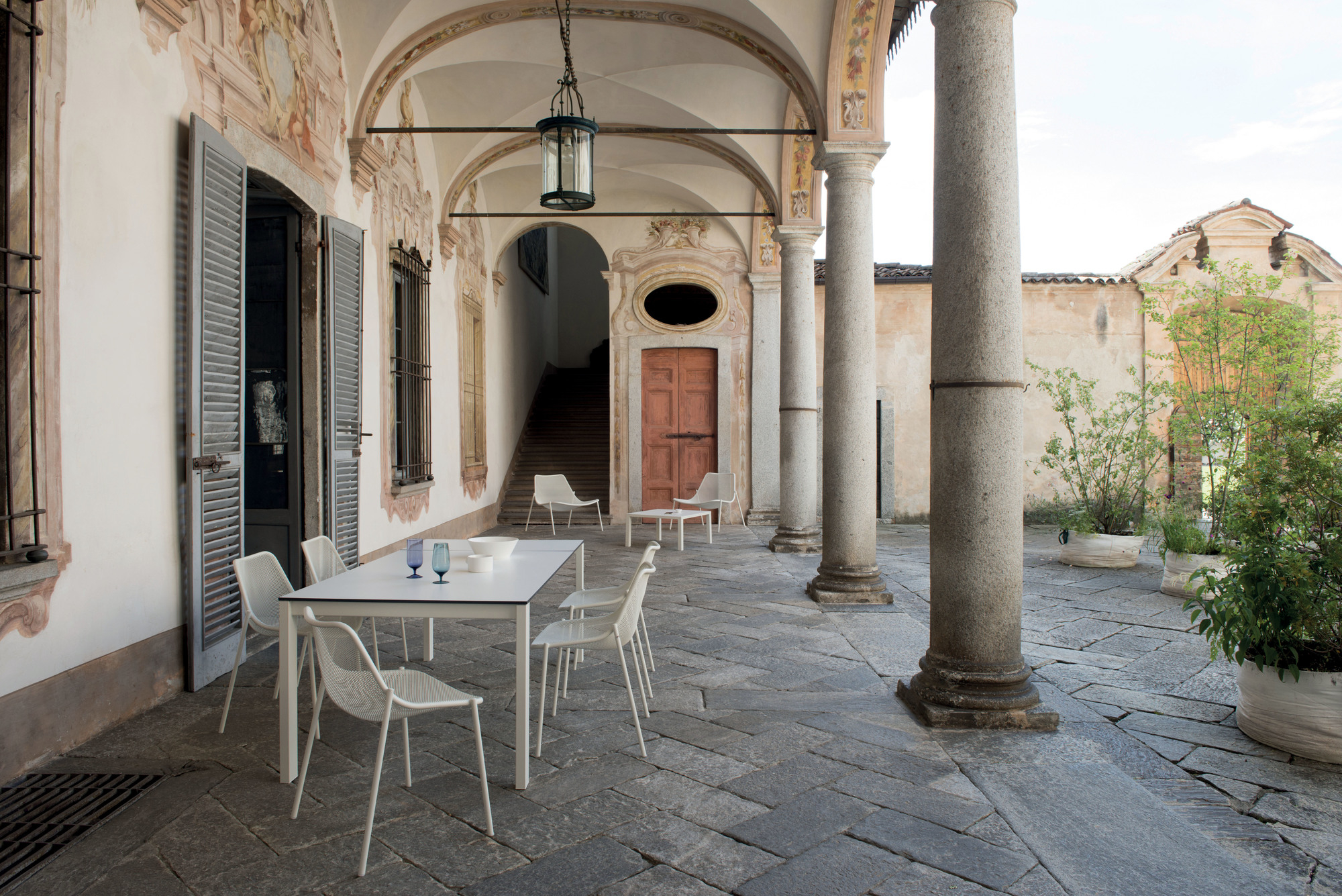 Weißer Emu Round Stuhl aus Metall im Außenbereich, Teil einer Gartengarnitur.