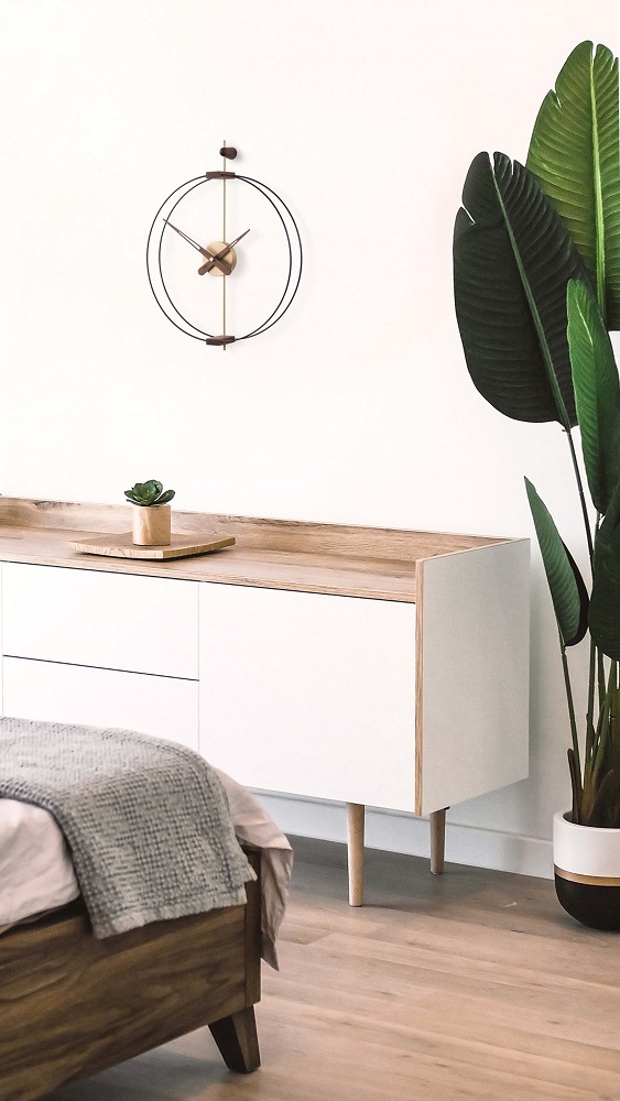 Nomon Barcelona Clock Wanduhr in Schwarz über modernem Sideboard im Schlafzimmer. Dekorative Wanduhr.