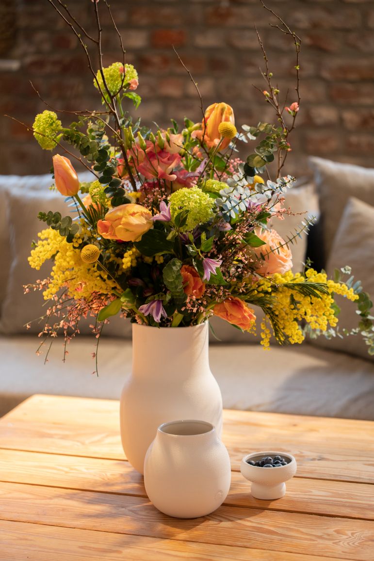 Living Perlenvase: Arrangement mit bunten Blumen in weißer Vase auf Holztisch, Deko, Kunststück.