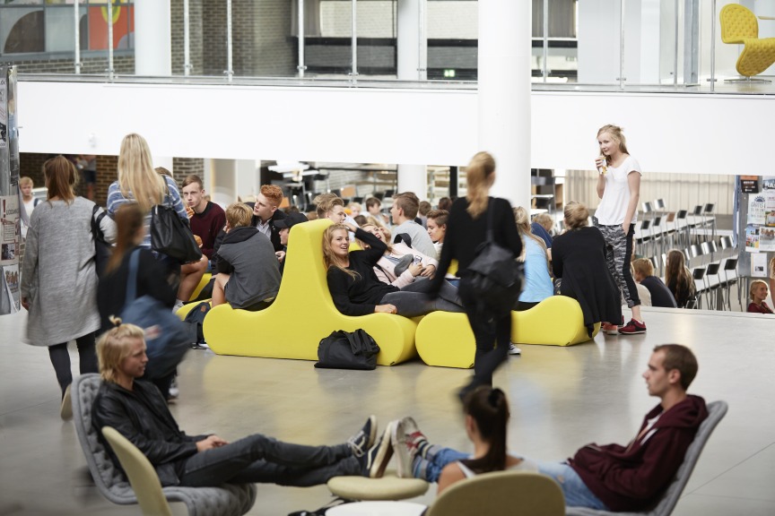 Gelbes Welle 1 Sofa von Verpan mit zwei Sitzen in einer modernen, öffentlichen Wartehalle.