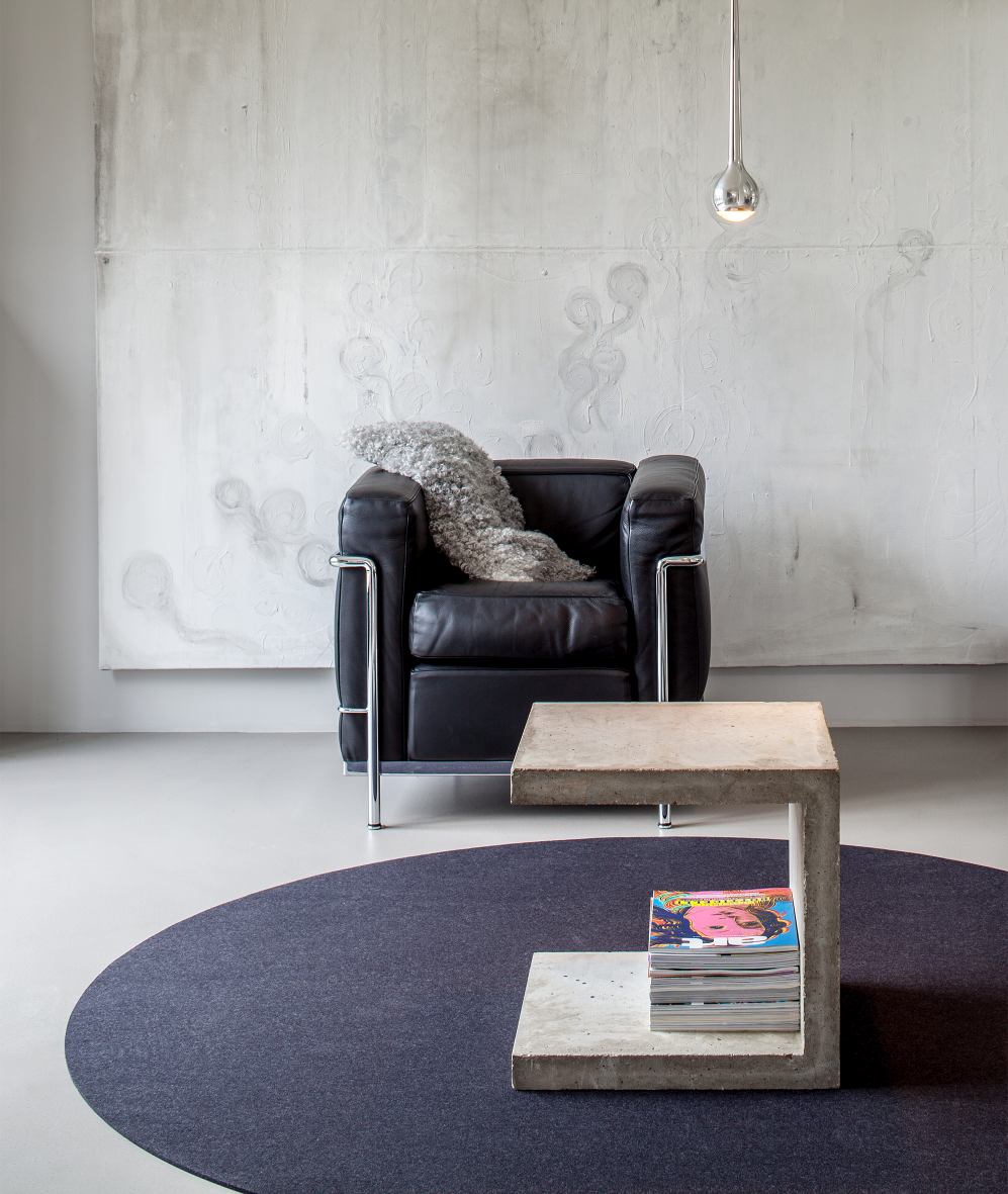 Dunkelblauer, runder Teppich Bigdot von Hey Sign unter einem Sessel und einem Beistelltisch aus Beton.
