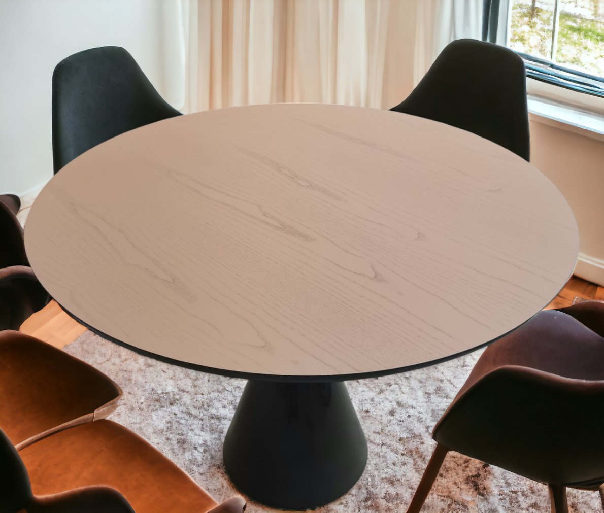 Runder Pion Esstisch mit heller Tischplatte und schwarzem Fuß, umgeben von Stühlen.