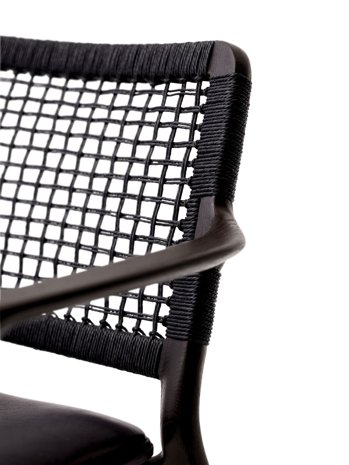 Detailaufnahme des Vipp Cabin Lounge Stuhls: Schwarzes Holzgestell mit geflochtener Rückenlehne und Armlehne.