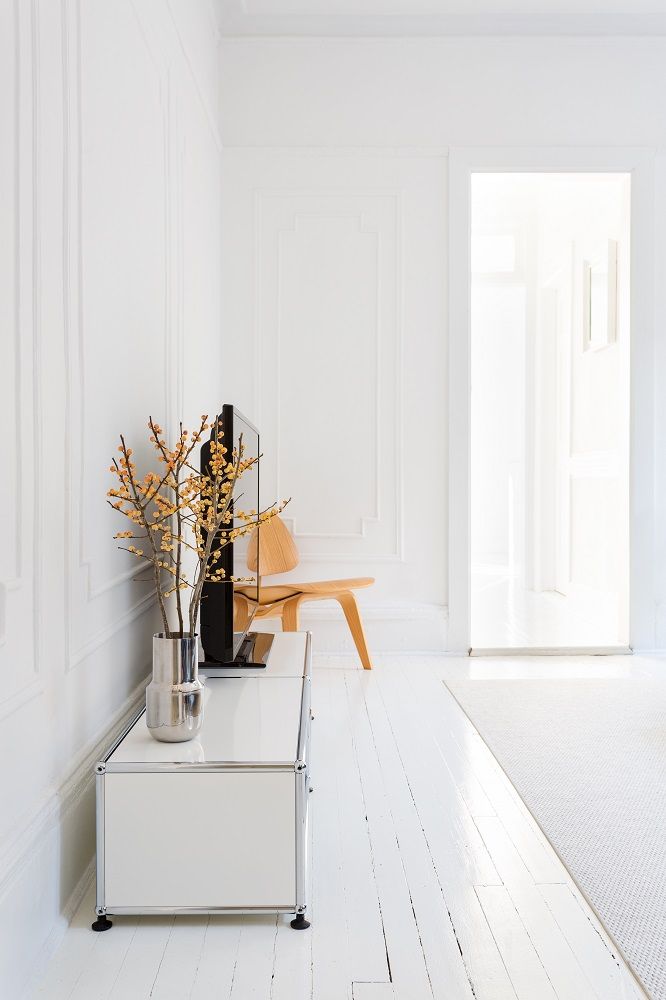 Beige USM Haller E TV-Möbel mit dimmbarem Licht in einem hellen, minimalistischen Wohnzimmer.